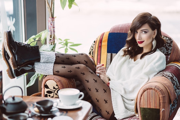 Young girl drinking coffee in a trendy cafe