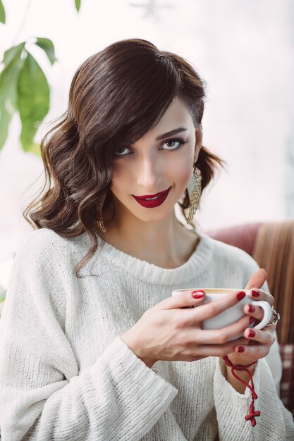 Young girl drinking coffee in a trendy cafe