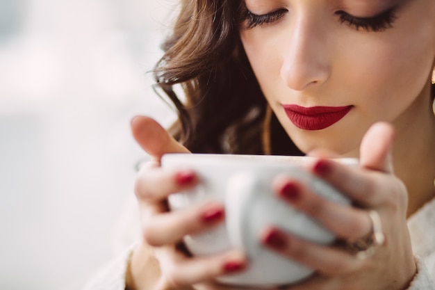 Foto gratuita ragazza che beve caffè in un caffè alla moda