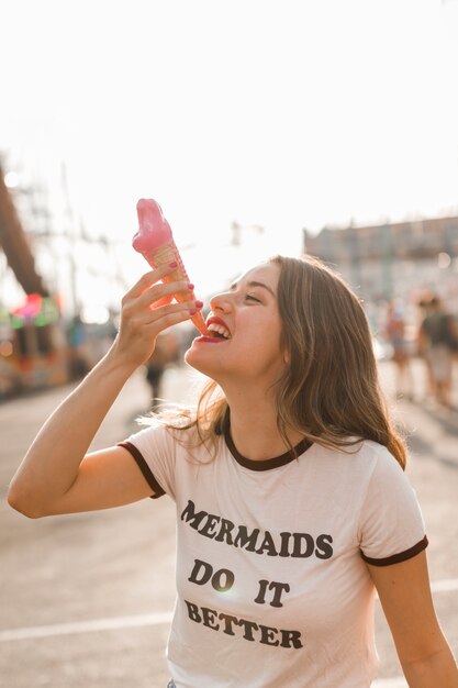 Young girl eating ice cream in the amusement park