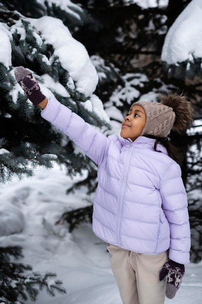 Free photo young girl enjoying a snowy winter day outdoors