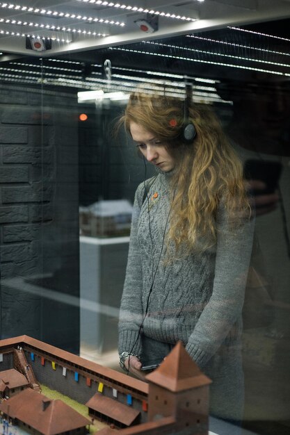 Free photo young girl at the exhibition of miniature architecture