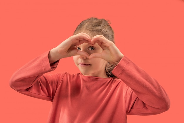 Young girl forming a heart with her fingers