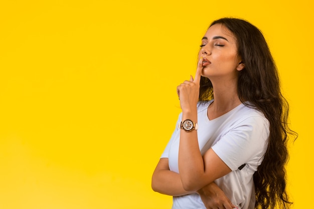 La ragazza dà il segno di silenzio in modo romantico.