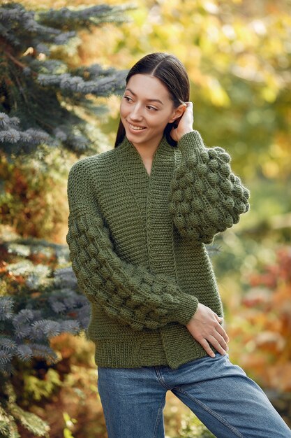 야외 포즈 녹색 스웨터에 어린 소녀