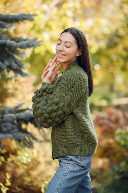 Young girl in a green sweater posing outdoors