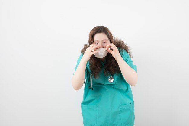 young girl in green uniform wearing medical mask .