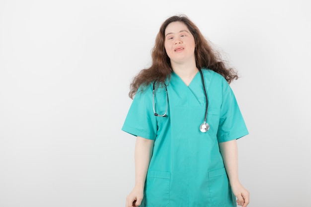 young girl in green uniform with stethoscope standing and posing .