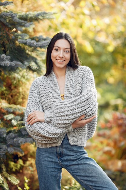 Young girl in a grey sweater posing outdoors