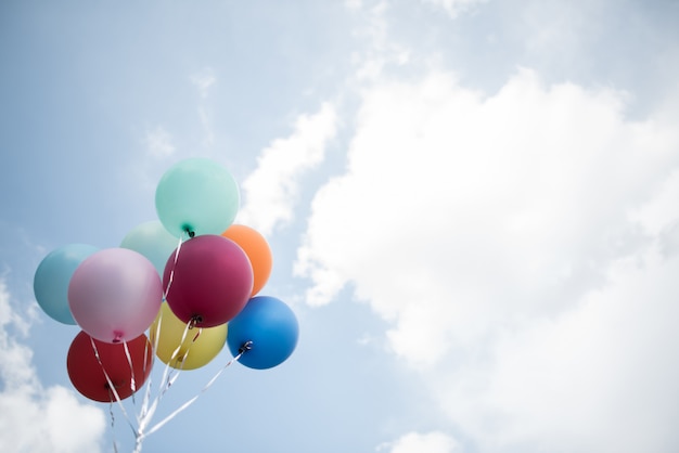 Young girl hand holding colorful balloons