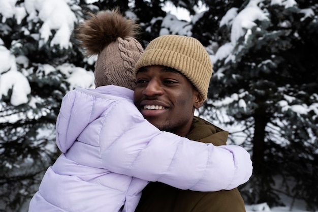 Young girl having fun with her father on a snowy winter day