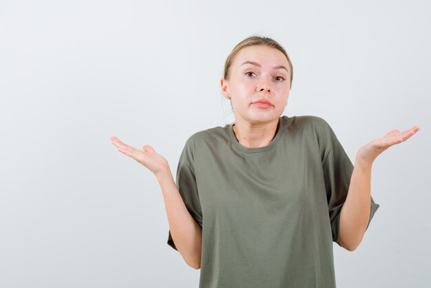 Young girl having no idea about topic on white background