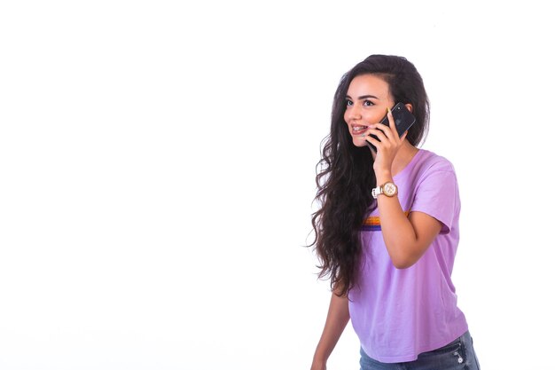 Young girl having a phone call and talking with a black smartphone.