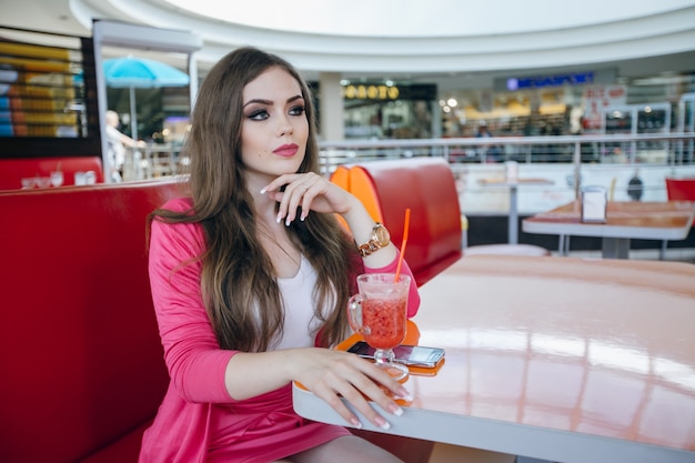 Young girl having a soda in a shopping center