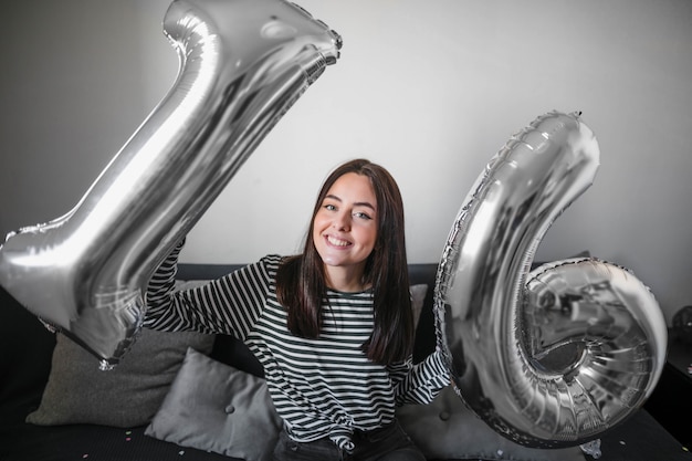 Free photo young girl holding balloons for birthday party