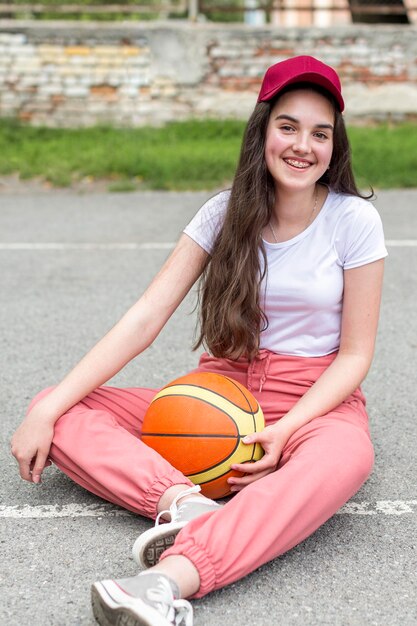 앉아있는 동안 농구를 들고 어린 소녀
