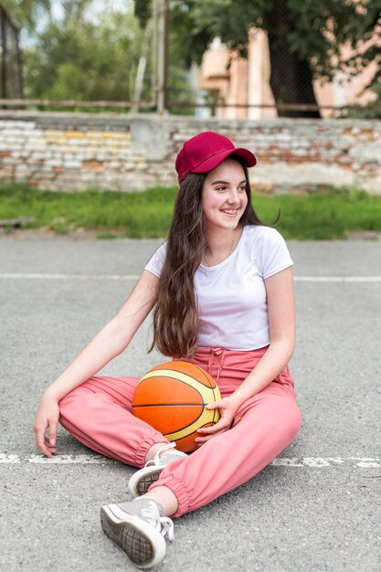 Молодая девушка держит баскетбол