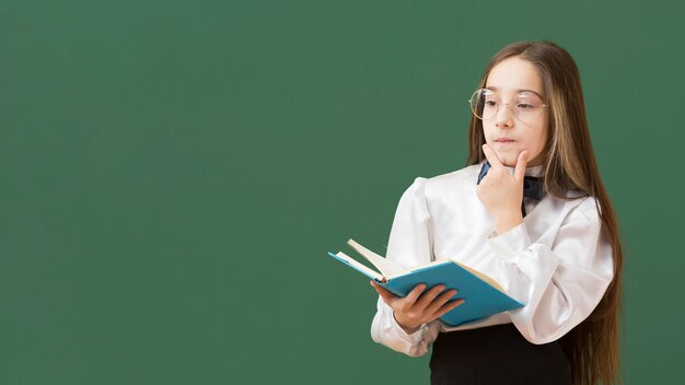 Young girl holding book copy space