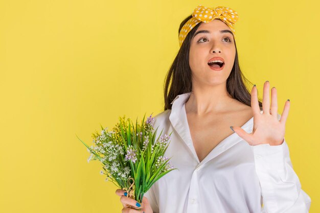 A young girl holding a bunch of flowers and holding her hand open High quality photo