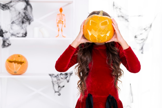 Young girl holding carved pumpkin