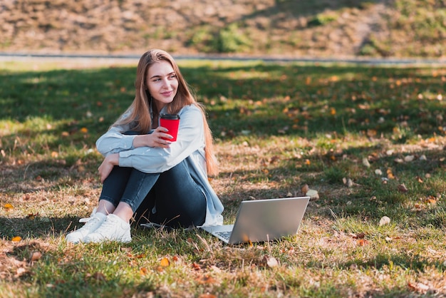 Foto gratuita ragazza che tiene una tazza nella natura