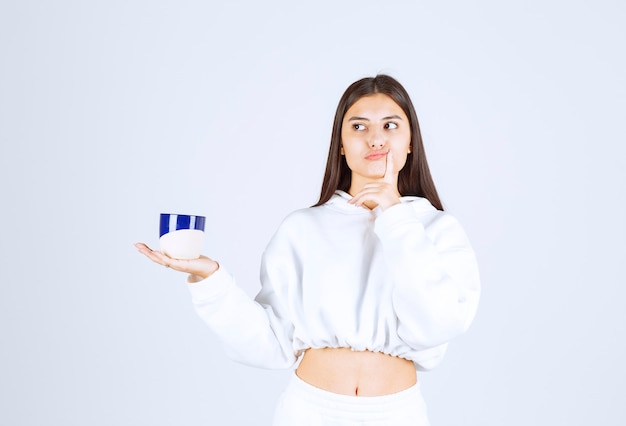 young girl holding a cup on white-gray background.