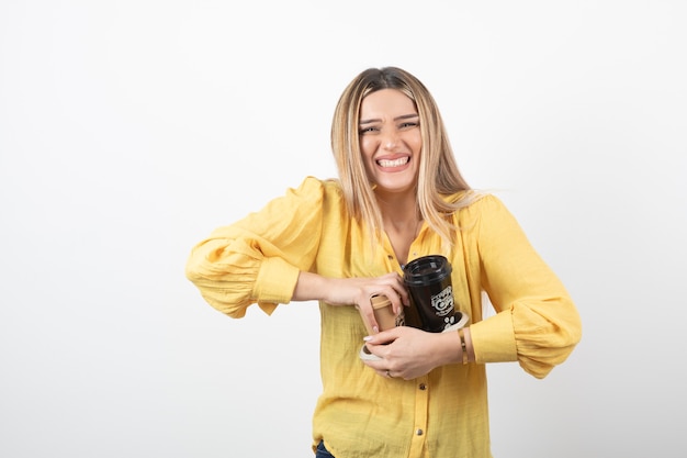 young girl holding cups of coffee on white.