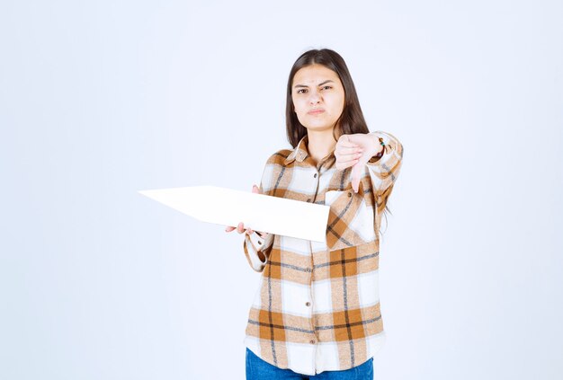 Young girl holding empty speech arrow pointer and giving thumbs down. 