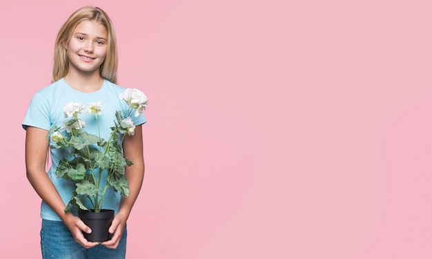 Young girl holding flower pot