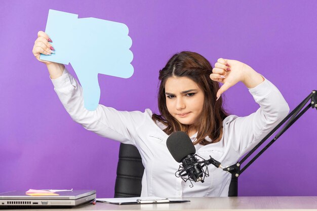 Young girl holding idea bubble in a hand shape and gesture thumb down High quality photo