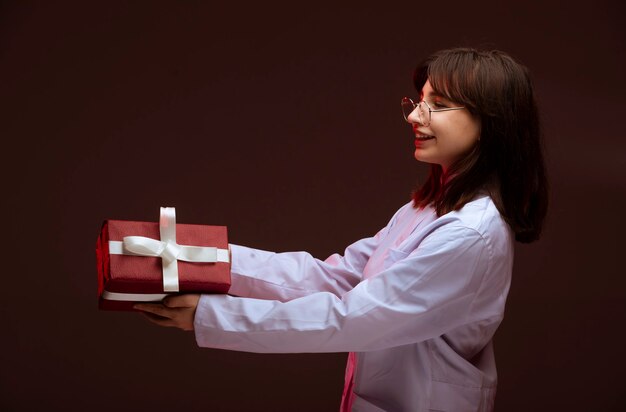 Young girl holding a red gift box and looking at.