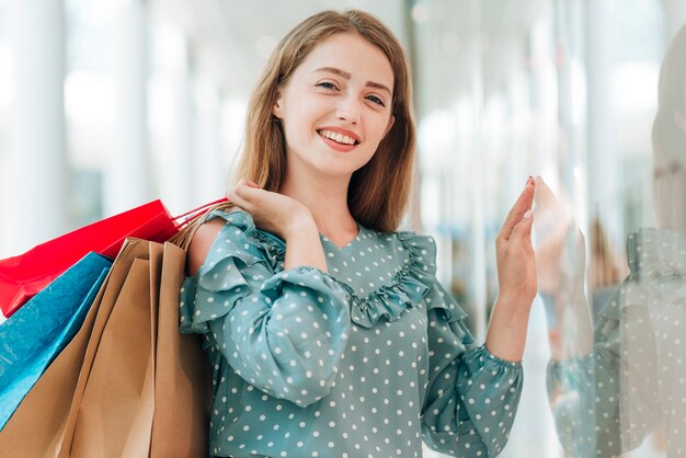 Young girl holding shopping bags medium shot