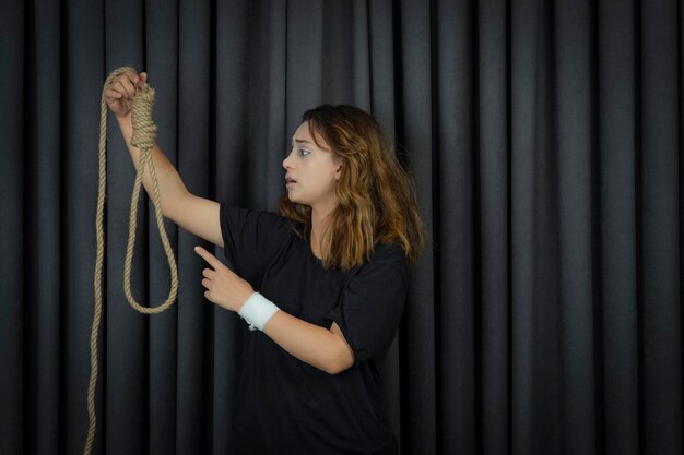 Young girl holding suicide rope and saying no to it. High quality photo