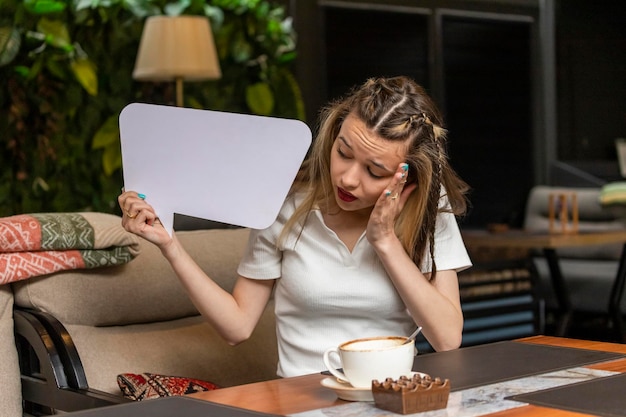 Free photo young girl holding white idea board and looking at it