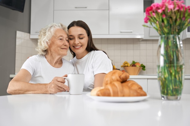 Ragazza che abbraccia la nonna in cucina