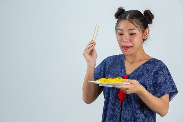 若い女の子は自宅でスパゲッティを食べることを楽しむ