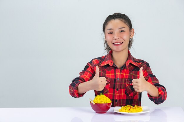 若い女の子は自宅でスパゲッティを食べることを楽しむ