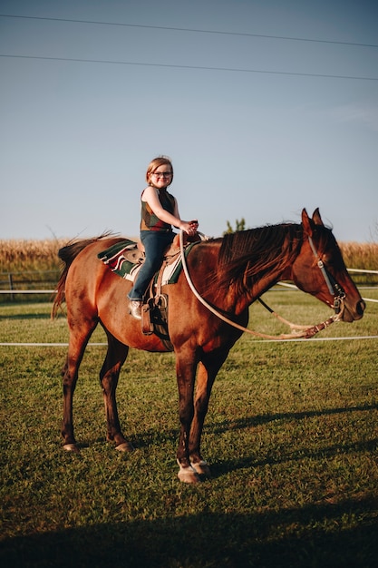 Foto gratuita la ragazza sta godendo di un'equitazione