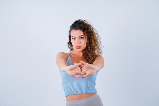 Young girl is extending hands to camera by holding them together on white background