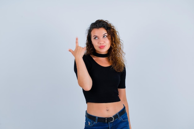 Young girl is looking up and pointing up with forefinegr on white background