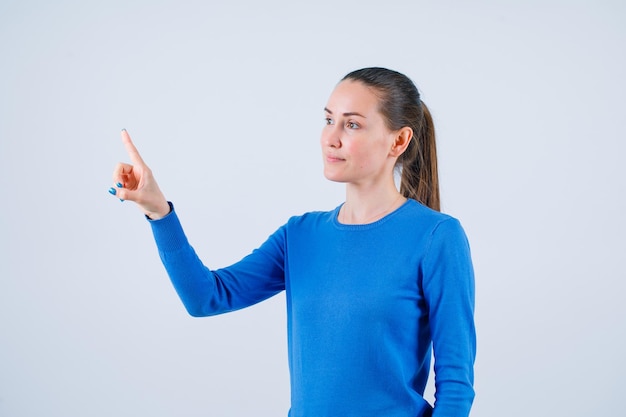 Free photo young girl is raising up her forefinger on white background