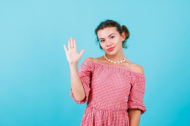 Young girl is raising up her handful on blue background