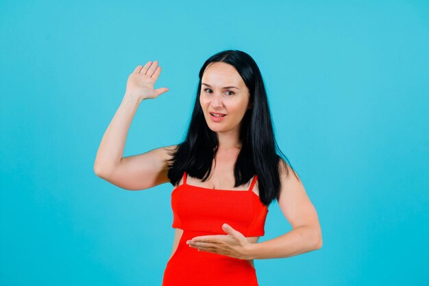 Young girl is showing hand gestures on blue background