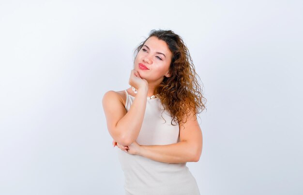 La ragazza sta pensando distogliendo lo sguardo su sfondo bianco