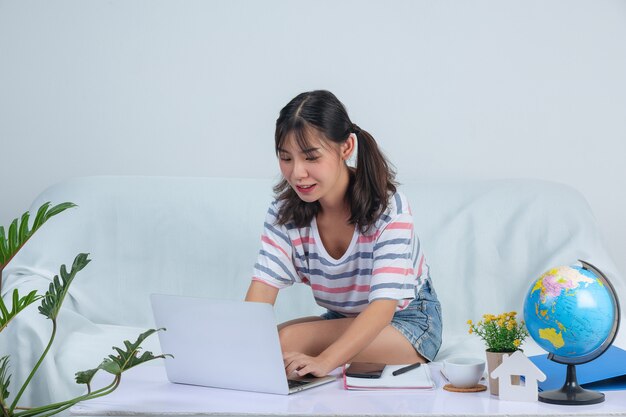 Young girl is working while using labptop on sofa at home