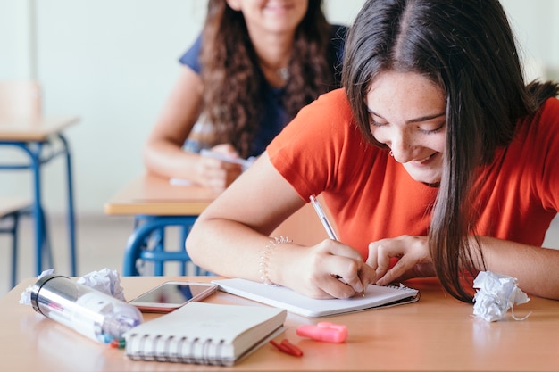 Young girl laughing and writing