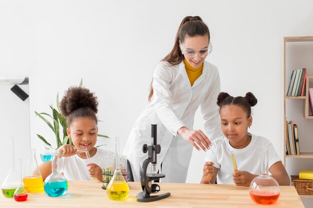 Young girl learning about chemistry from female scientist