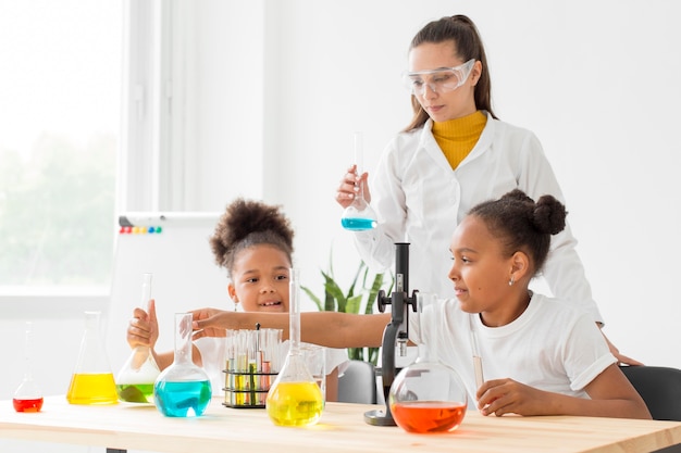 Young girl learning about science from female scientist