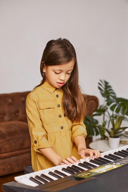 電子キーボードの演奏方法を学ぶ少女
