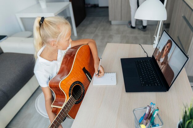 Young girl learning how to play guitar